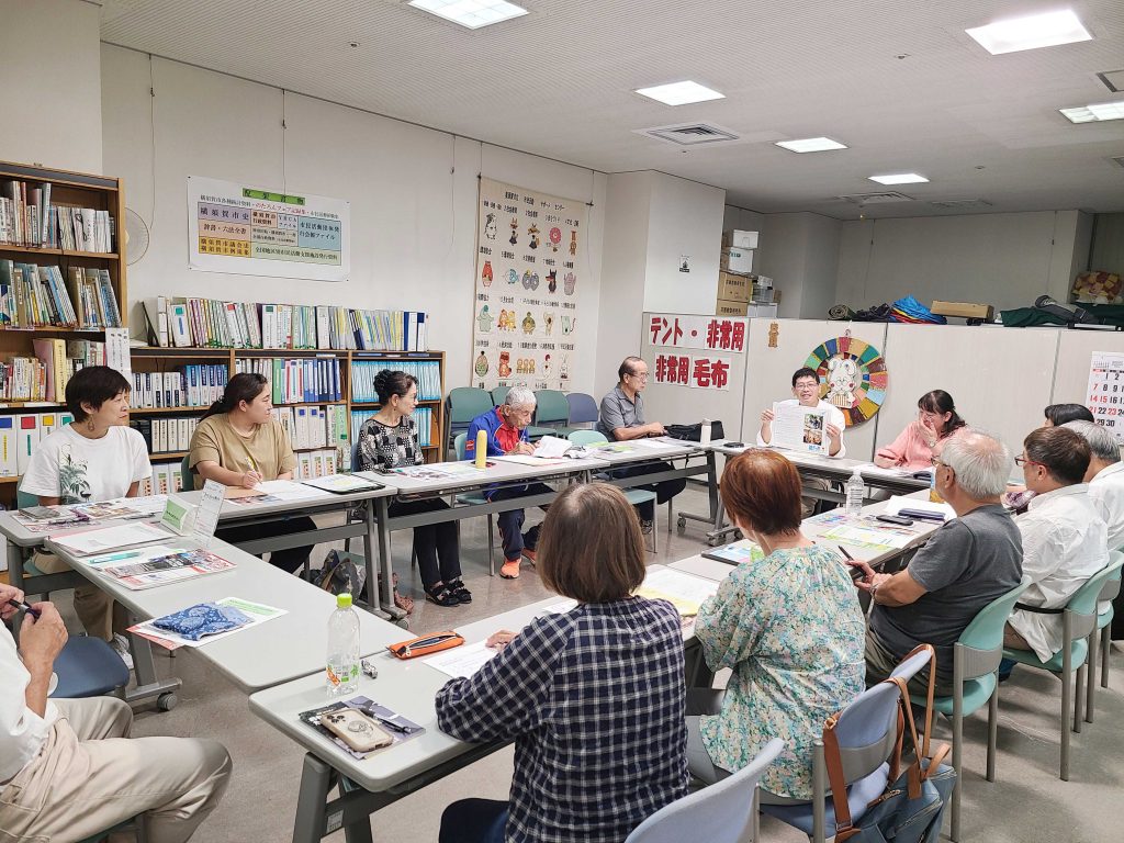 報告会で話し合っている14人の参加者